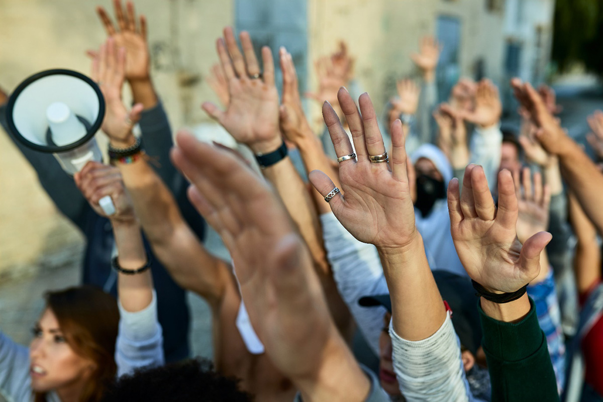 2024: година на екстремната десница. Фотографија на која се гледаат кренати раце на луѓе кои учествуваат во протест.